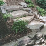 Mulched planting beds flanking stone walkway