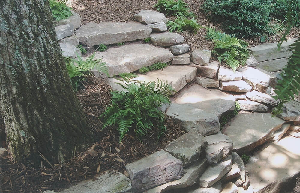 Mulched planting beds flanking stone walkway